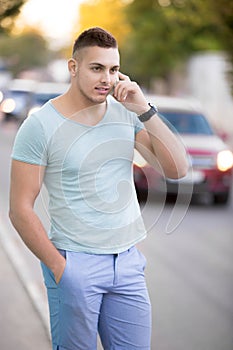 Young man on cell phone on city street