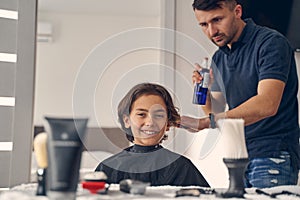 Young man changing hairstyle for little boy