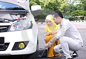 Young man changing the punctured tyre