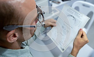 Young man checking his eyes to make glasses