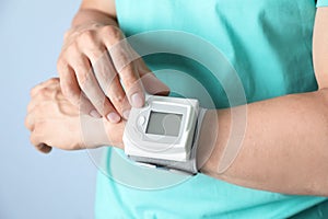 Young man checking pulse with blood pressure monitor