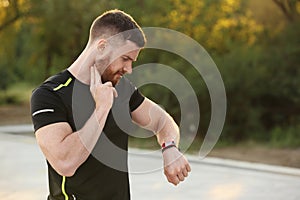 Young man checking pulse after workout