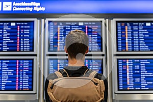Young man checking the timetable at the airport