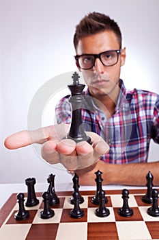 Young man chess player holding up his king