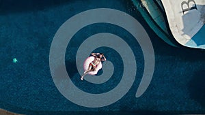 Young man chill swim in infinity pool with inflatable donut rubber ring