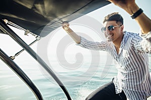 Young man chilling on the modern yacht deck. Sailing the sea.