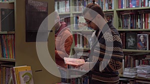 Young man chooses a book in a bookstore