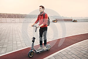 Young man chooses not public transport, but a personal or rented electric scooter to get to work quickly and safely