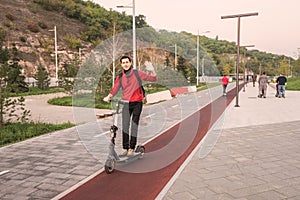 young man chooses not public transport, but a personal or rented electric scooter to get to work quickly and safely
