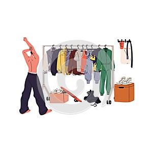 Young man choosing stylish outfit back view. Guy looks on closet, makes choice of garment on hanger rack. Wardrobe rail
