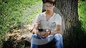 Young man in city park using ebook reader