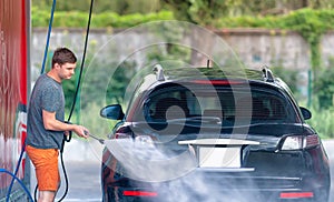 Young man cleaning his car