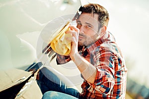 Young man cleaning his car