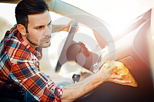 Young man cleaning his car outdoors