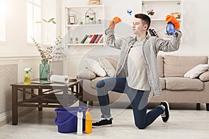 Young man cleaning home and having fun