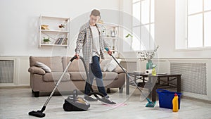 Young man cleaning house with lots of tools