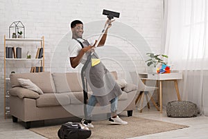 Young man cleaning house with vacuum cleaner