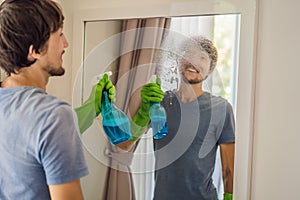 Young man cleaning mirror at home hotel