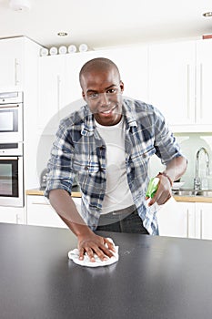 Young Man Cleaning Modern Kitchen