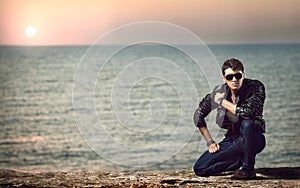 Young man on cliff near water