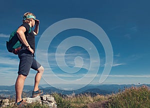 Young man climber on the top of mountain