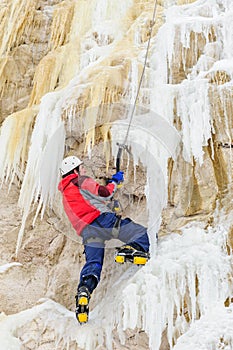 Young man climbing the ice