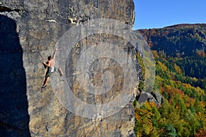 Young man is climbing on the sandstone rock in Sachsen Switzerland.