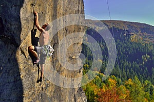 Young man is climbing on the sandstone rock in Sachsen Switzerland.