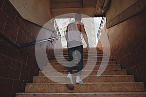 Young man climbing stairs in pedestrian subway