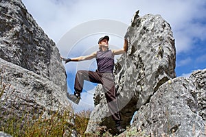 Young man climbs on rock