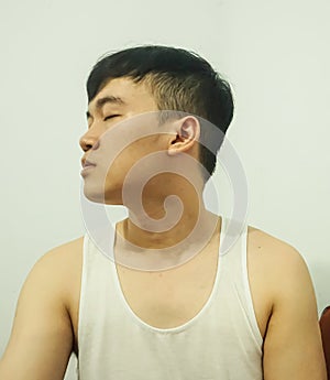 young man closing eyes in white singlet