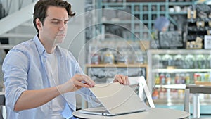 Creativo hombre final computadora portátil común lejos en cafetería 