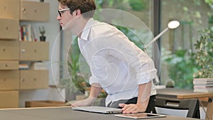 Young Man Closing Laptop and Leaving Modern Office
