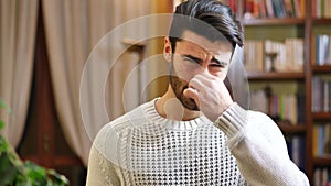 Young man closing nose for bad smell