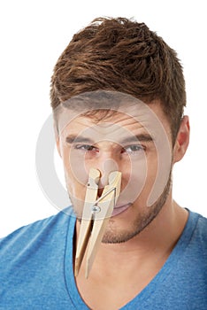 Young man with clothespin on his nose.