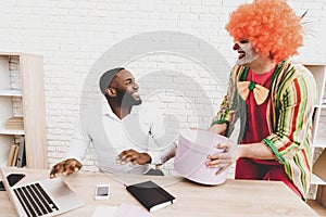 Young Man in Clown Costume on Meeting in Office.