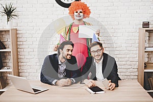 Young Man in Clown Costume on Meeting in Office.