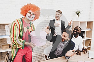 Young Man in Clown Costume on Meeting in Office.