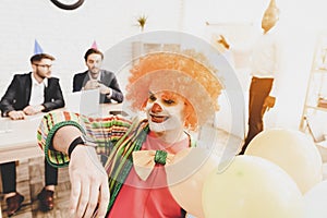 Young Man in Clown Costume on Meeting in Office.