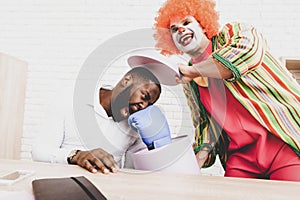 Young Man in Clown Costume on Meeting in Office.