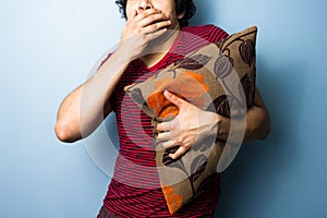 Young man clutching cushion while watching scary movie