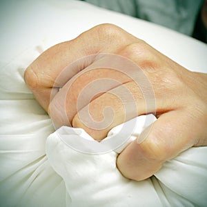 Young man clutching tightly his pillow in bed photo