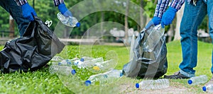 A young man collects plastic bottles in a garbage bag as a way to clean up the garden. The idea is to protect the environment.