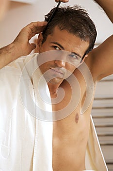 Young man combing his hair