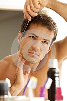 Young man combing his hair