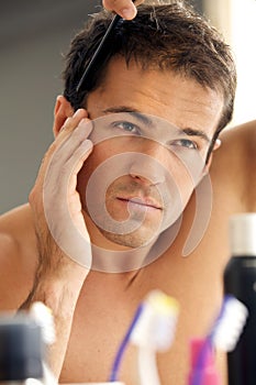 Young man combing his hair photo