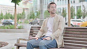 Young Man Coming, Sitting on Bench and Checking Time