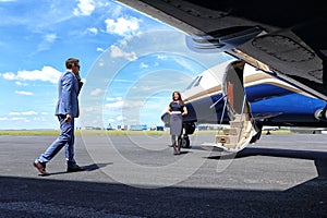 Young man coming to his jet with a welcoming air hostess air hostess