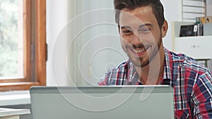 A young man communicates via video communication on a computer