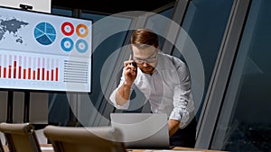 Young man communicating with a customer using a phone in workplace